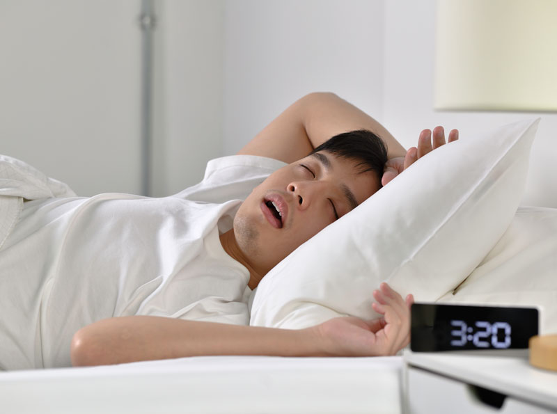 Man laying in bed snoring