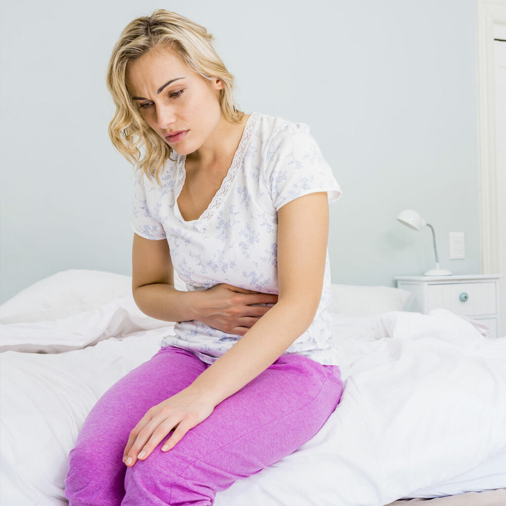 Woman holding stomach having digestive issues